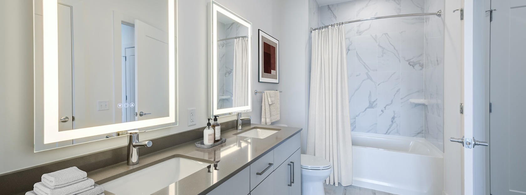lighted mirrors in bathroom with dual sinks
