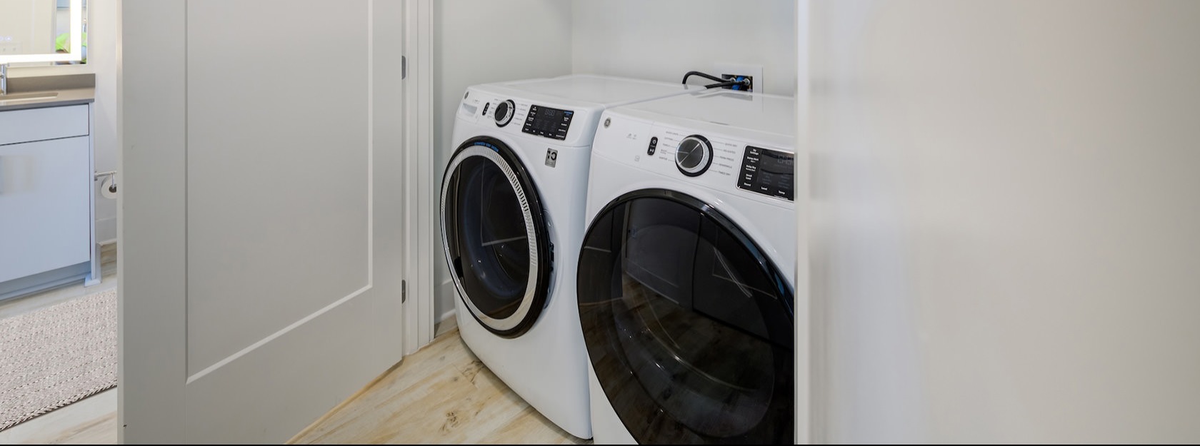 double doored laundry closet with side-by-side washer/dryer units
