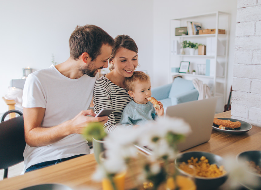 Family smiling and looking at a laptop